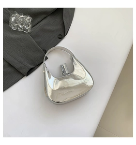 Macro view of silver mirror finish moon bag featuring polished metallic texture and zipper