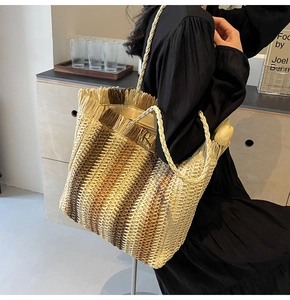 Detail of woven straw tote bag with multi-color gradient stripes and tassel edge
