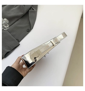 Top-down view of a shiny silver metallic handbag with a reflective mirror finish