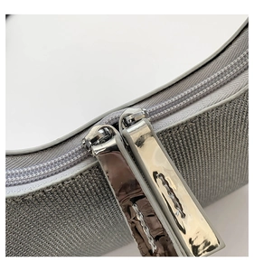 Macro shot of glittery rhinestone mesh fabric and premium silver metal zipper details