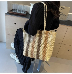Detail of bohemian woven tote bag showing fringe edges and gradient straw texture