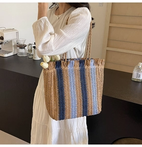 Detail of multi-color woven tote bag with fringe accents in a cozy indoor cafe setting