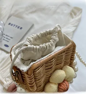 Detail of woven straw bag with floral accents and a premium faux pearl strap handle