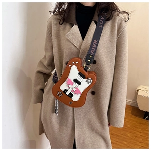 Detail view of the guitar shaped crossbody bag with brown leather and flame pattern