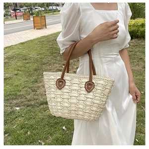Close-up of honeycomb weave texture and brown leather handle on straw beach bag