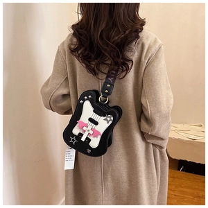 Creative guitar-shaped crossbody bag with wings and stars shown on a model