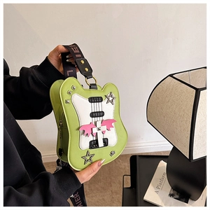 Detail of guitar-shaped green PU leather bag with rhinestone cross and studded wings