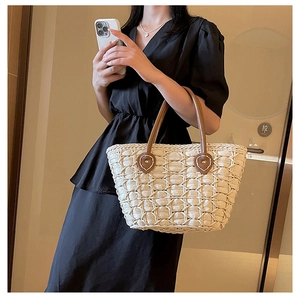 Close-up of beige woven mesh fabric on a stylish tote bag with brown leather handles