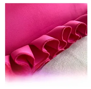 Macro detail of the ruffled fabric edges and pleats on the pink shoulder bag