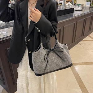 Grey tweed tote bag with black leather bow accent and handles for autumn fashion