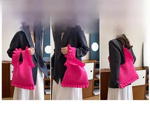 Detailed view of hot pink shoulder bag featuring ruffled edges and removable strap options