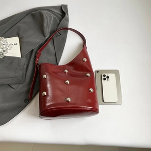 Deep red hobo shoulder bag with silver rivet studs and glossy finish on a white background