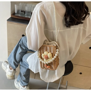 Detail of handmade straw woven bag featuring a 3D sunflower and pearl strap
