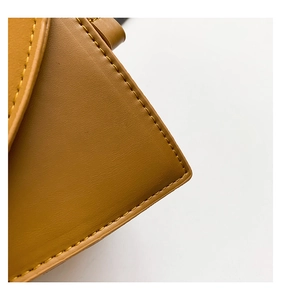 Macro detail of brown leather bag showing premium stitching and fine pebble texture