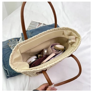 Top view of spacious straw tote interior with lining and daily essentials