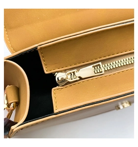Detail of yellow PU leather bag featuring a smooth gold zipper and black inner lining