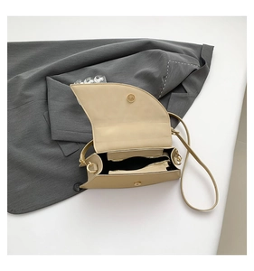 Detail view of the beige saddle bag's interior lining and internal zipper pocket