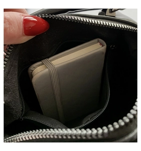 Internal view of black y2k bag showing zipper pocket and capacity for a notebook