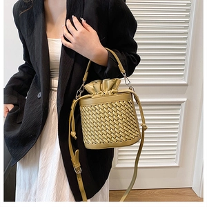 Detail of woven texture and drawstring closure on mustard green PU leather bucket bag