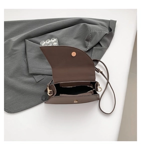 Detail view of brown leather handbag interior with gold hardware and zipper pocket