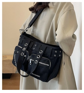 Détail du sac à bandoulière punk en toile noire avec œillets, rivets et chaînes