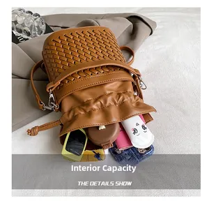 Internal capacity of woven bucket bag showing sunglasses, phone, and makeup essentials