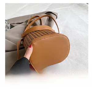 Close-up of the durable leather oval bottom on a brown woven bucket handbag