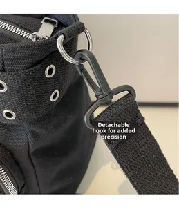 Détail du crochet amovible en métal noir mat et du zip sur le sac fourre-tout en toile