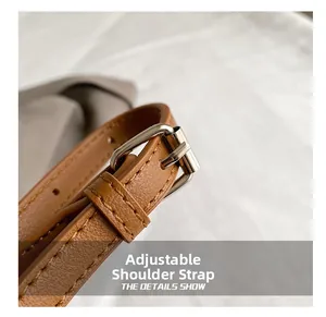 Macro shot of adjustable brown lychee pattern leather shoulder strap with silver buckle