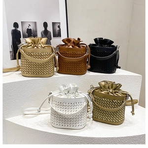 Detail shot of five elegant woven bucket bags in beige, brown, black, white, and green