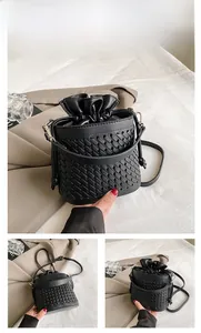 Detail of black woven bucket bag showing intricate texture and drawstring inner pouch
