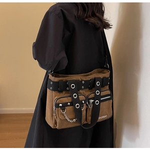 Vue détaillée du sac en toile marron avec rivets et chaînes métalliques style punk