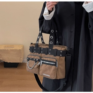 Détail d'un sac cabas punk en toile marron avec clous argentés et décorations de chaînes