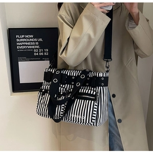 Vue détaillée du sac en toile punk à rayures avec rivets et chaînes sur un modèle