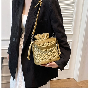 Detailed woven texture and satin drawstring closure of the mustard yellow bucket bag