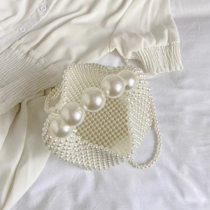 Sac à main élégant tissé en perles blanches avec grande poignée sur tissu texturé