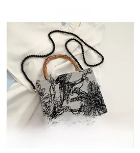 Detail of vintage canvas tote with tropical bird print, bamboo handle and bead strap