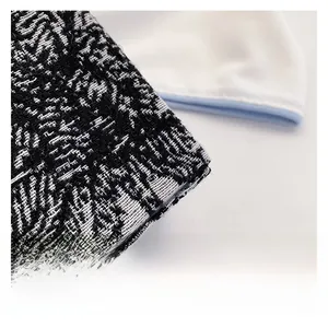Detailed close-up showing the black and white jacquard woven fabric texture of the handbag