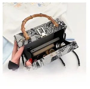 Top view of floral jacquard handbag with bamboo handle, beaded strap and inner capacity
