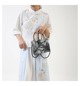 Detail of bamboo handle and ink-style embroidery on this elegant Chinese evening handbag