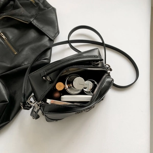 Y2K style cross crossbody bag in black matte finish showing interior storage capacity