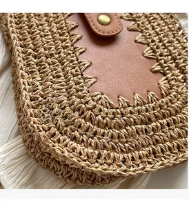 Close-up of straw woven texture with brown leather flap and golden metal button