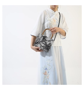Detailed view of bamboo handle and ink landscape print on minimalist fabric tote bag