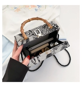 Detail view of woven box bag interior showing capacity for phone and essentials