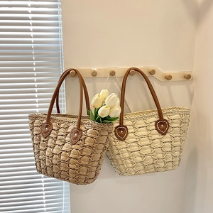 Handwoven straw tote bags with leather handles in natural and cream colors for beach