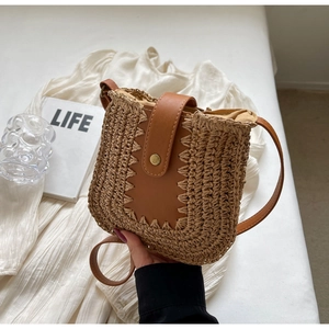 Détail du sac à bandoulière en paille tressée avec sangle en cuir et fermoir magnétique
