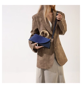 Détail du sac à main bleu marine avec texture crocodile et poignée en métal doré chic