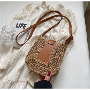 Détail du sac en paille tissé à la main avec garniture en cuir marron et clous dorés