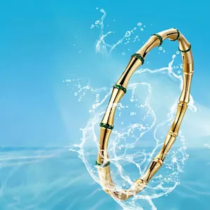 Elegant gold bamboo style titanium steel bangle with green crystals and waterproof finish