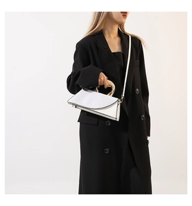 Vue détaillée du sac à main blanc motif crocodile avec poignée moderne en métal doré